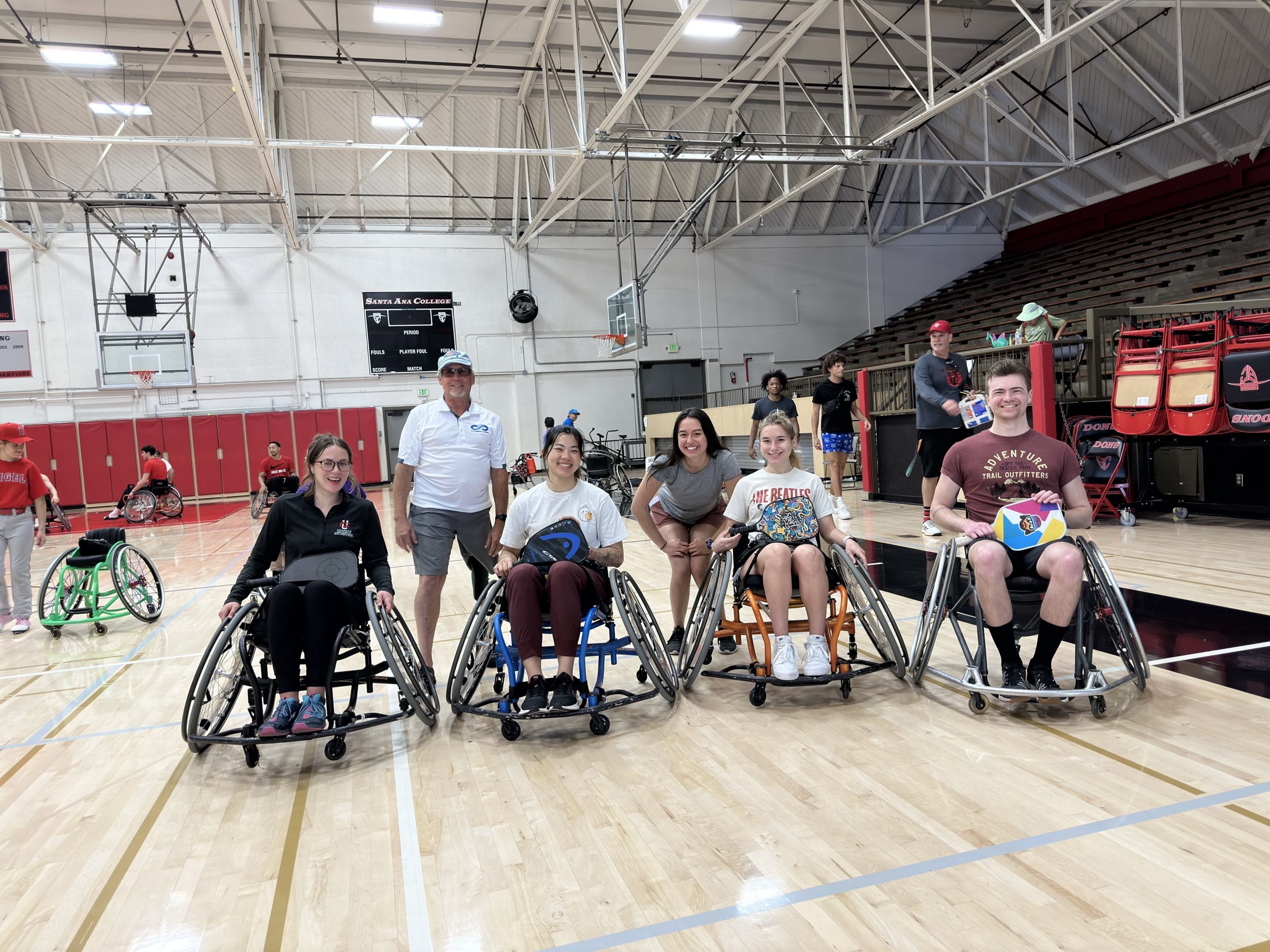 Adaptive athletes gather as a proud team in their sport wheelchairs.